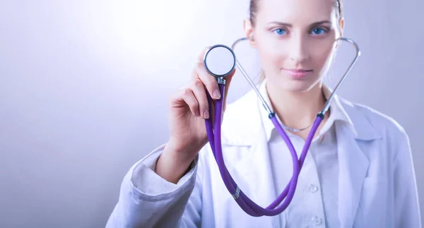 Seorang dokter wanita muda mendengarkan, memegang stetoskop medis — Stok Foto