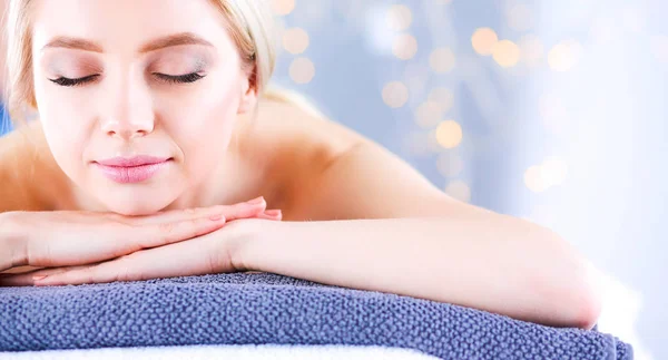 Jonge vrouw liggend op een massagetafel, ontspannen met ogen dicht — Stockfoto
