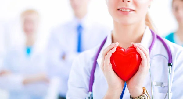 Ärztin mit Stethoskop hält rotes Herz — Stockfoto