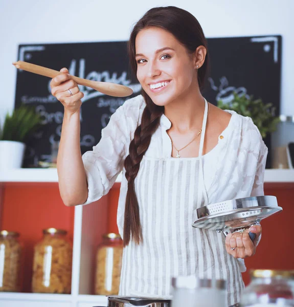 Кулінарія жінки на кухні з дерев'яною ложкою — стокове фото