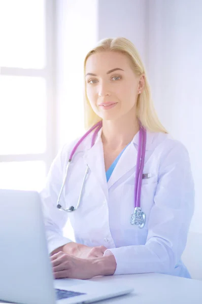 Kobieta lekarz siedzi na biurku i pracuje na laptopie w szpitalu — Zdjęcie stockowe