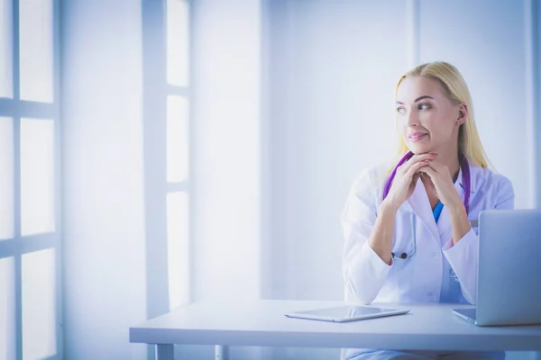 Női orvos ül az asztalon, és dolgozik egy laptop a kórházban — Stock Fotó