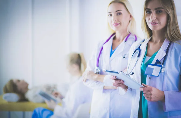 Porträt von drei selbstbewussten Ärztinnen, die mit verschränkten Armen in der Arztpraxis stehen — Stockfoto