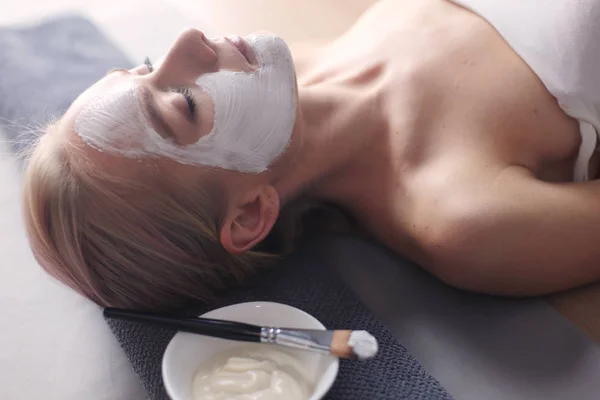 Mascarilla facial. Hermosa joven en el spa, mujer cosmética aplicando mascarilla facial —  Fotos de Stock