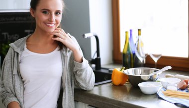 Mutfakta masada oturan genç bir kadın. .