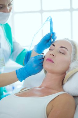 Kaşlar için kalıcı makyaj. Güzellik salonunda kalın kaşlı güzel bir kadın.