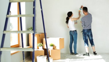 Mutlu gülümseyen genç çift boya iç cephe yeni evin portresi