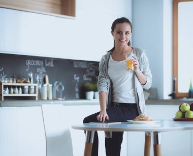 Tablette tarifi takip eden bir kadın evde yemek pişiriyor.