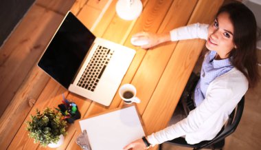 Masada oturan genç bir kadın.