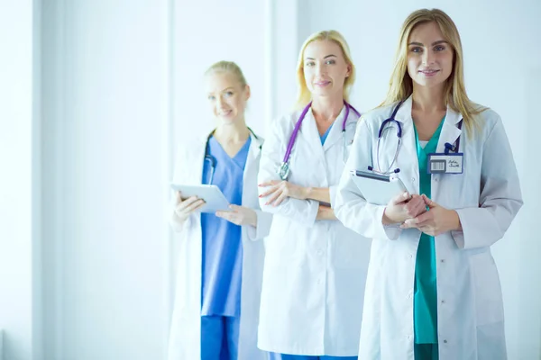 Retrato de tres doctores confiados de pie con los brazos cruzados en el consultorio médico —  Fotos de Stock