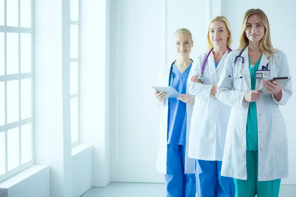 Portrait of three confident female doctors standing with arms crossed at the medical office — Stock Photo, Image