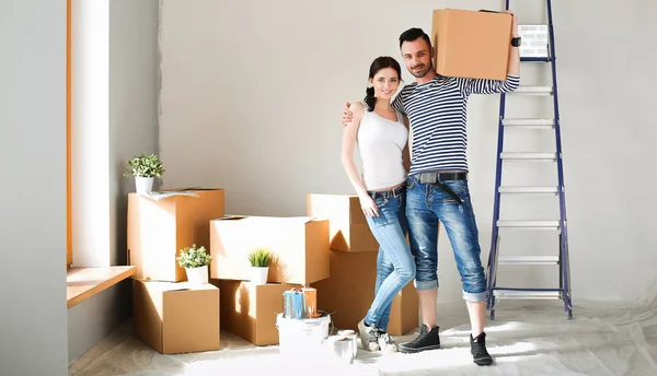 Gelukkige jonge paar uitpakken of dozen inpakken en verhuizen naar een nieuw huis — Stockfoto