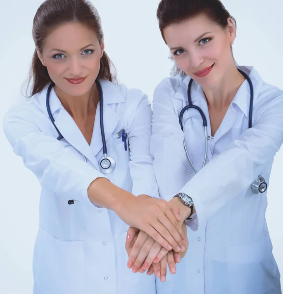 Médecins et infirmières empilent les mains. Isolé sur fond blanc — Photo