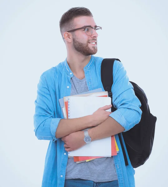 Jovem estudante do sexo masculino com saco escolar segurando livros isolados em fundo branco — Fotografia de Stock