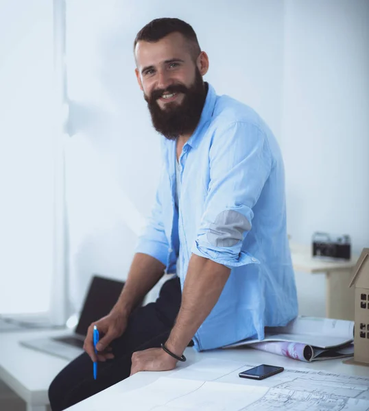 Portrait of male designer in hat with blueprints at desk — Stock Photo, Image