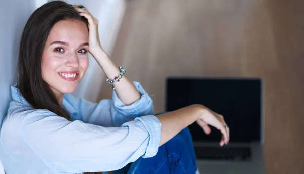 Ung kvinna sitter på sängen nära barnens barnsäng — Stockfoto