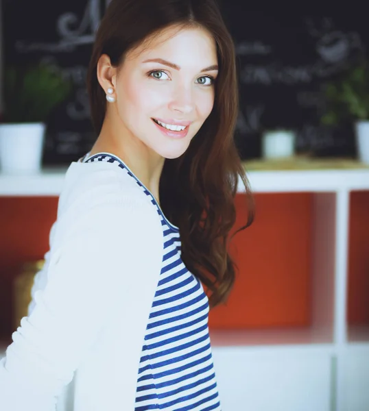 Young woman standing near desk in the kitchen — Stock Photo, Image