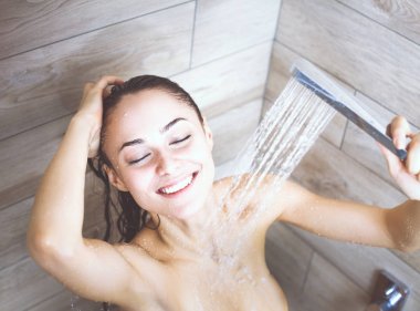 Genç beautyful kadın banyoda duş altında.