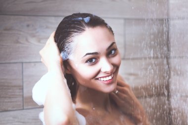 Genç beautyful kadın banyoda duş altında.
