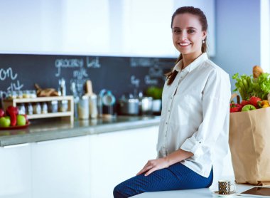 Giderleri planlama ve mutfağını faturalarında ödeme genç kadın.
