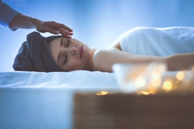 Masaj masasında uzanmış gözleri kapalı rahatlayan genç bir kadın. - Kadın. Spa salonu