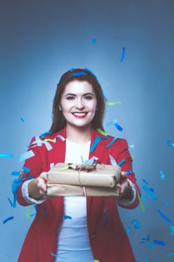 Hediye kutusu ile konfeti kutlama partisinde güzel mutlu kadınla. Doğum günü veya yeni yıl arifesi kavramı kutlama