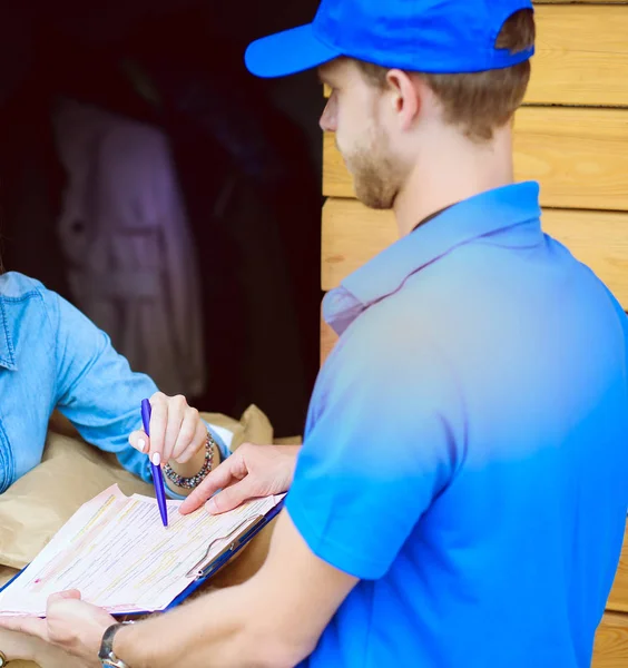Усміхнений чоловік доставки в синій формі доставки посилок до одержувача - концепція кур'єрської служби. Усміхнений чоловік доставки в синій формі — стокове фото