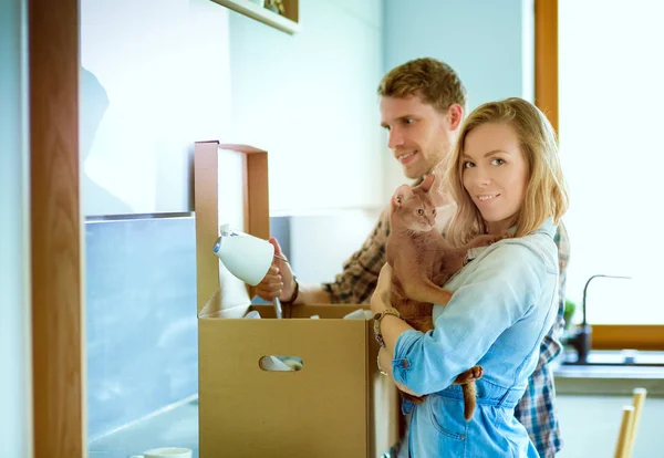 Νεαρό ζευγάρι που μεταφέρουν μεγάλο κουτί από χαρτόνι στο νέο σπίτι. Μετακόμιση. Νεαρό ζευγάρι — Φωτογραφία Αρχείου