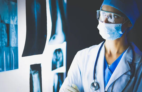 Зображення привабливої жінки-лікаря, який дивиться на результати рентгенівського випромінювання . — стокове фото