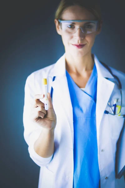 Medizinische oder wissenschaftliche Wissenschaftlerin oder Ärztin mit Blick auf ein Reagenzglas mit klarer Lösung in einem Labor oder Labor. — Stockfoto