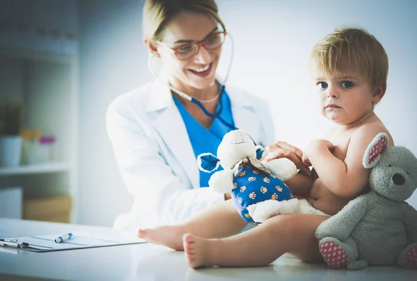 La doctora está escuchando a un niño con un estetoscopio en la clínica — Foto de Stock