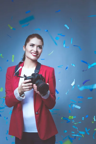 Beautiful happy woman with camera at celebration party with confetti . Birthday or New Year eve celebrating concept — Stock Photo, Image