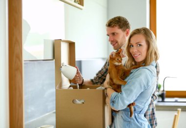 Genç bir çift yeni evde büyük karton kutu taşıyan. Ev taşıma. Genç Çift