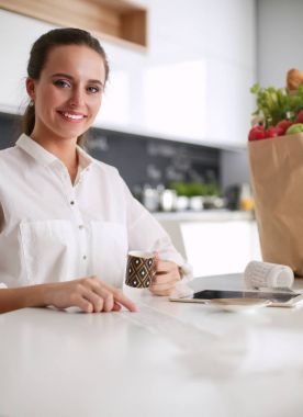 Giderleri planlama ve mutfağını faturalarında ödeme genç kadın.