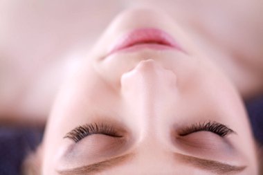 Masaj masasında uzanmış gözleri kapalı rahatlayan genç bir kadın. - Kadın. Spa salonu