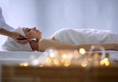 Masaj masasında uzanmış gözleri kapalı rahatlayan genç bir kadın. - Kadın. Spa salonu