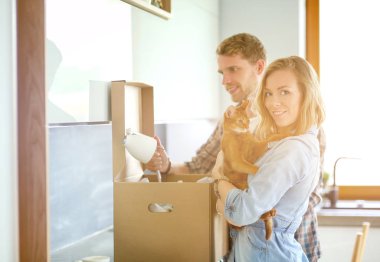 Genç bir çift yeni evde büyük karton kutu taşıyan. Ev taşıma. Genç Çift