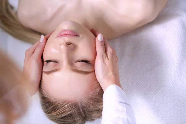 Jeune femme allongée sur une table de massage, relaxante les yeux fermés. Femme. Salon de spa — Photo