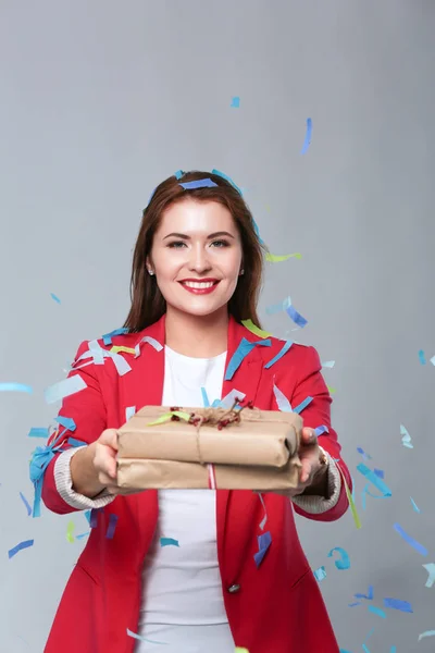 Hermosa mujer feliz con caja de regalo en la fiesta de celebración con confeti. Cumpleaños o Nochevieja celebrando el concepto —  Fotos de Stock