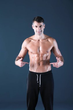 kaslı adam. Kaslı adam kas gösterilen gri arka plan üzerinde. Fitness Eğitmeni. Fitness profesyonel. Egzersiz. Mens fitness.