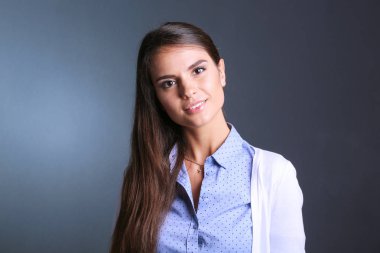 Esmer arka planda bir iş kadınının portresi. Gülümseyen kadın. Bir kadın portresi