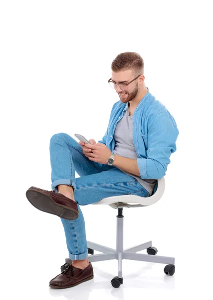 Mladý muž sedí na židli a pomocí mobilního telefonu. Startupper. Mladý podnikatel. — Stock fotografie
