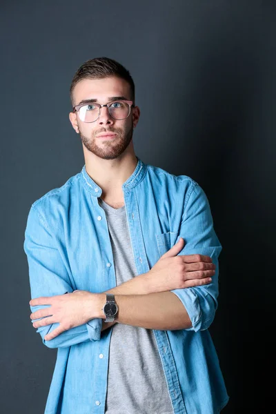 Portret van een gelukkig casual man permanent geïsoleerd op een donkere achtergrond. Knappe mannen poseren. — Stockfoto