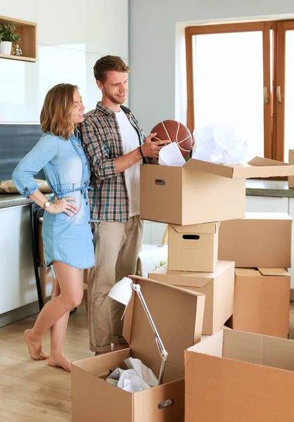 Couple unpacking cardboard boxes in their new home. Young couple. — Stock Photo, Image