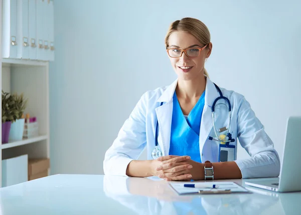 Doctor y pareja de pacientes están discutiendo algo, sentados en el escritorio. — Foto de Stock