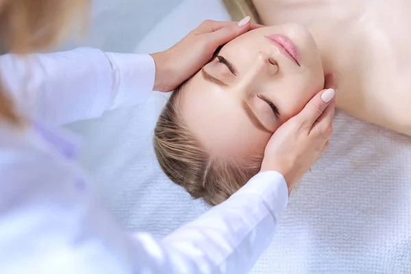 Jonge vrouw liggend op een massagetafel, ontspannend met gesloten ogen. Vrouw. Kuuroord — Stockfoto