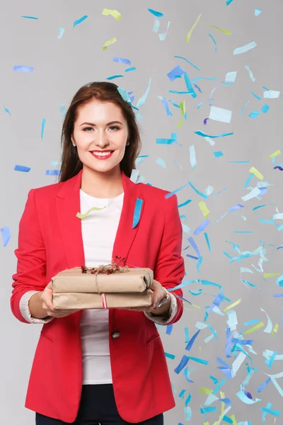 Mulher feliz bonita com caixa de presente na festa de celebração com confete. Aniversário ou véspera de Ano Novo celebrando conceito — Fotografia de Stock