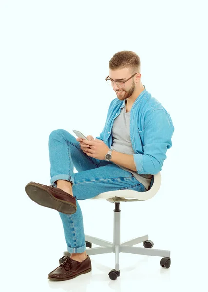 Junger Mann auf Stuhl sitzend und mit Handy. Startupper. Jungunternehmer. — Stockfoto