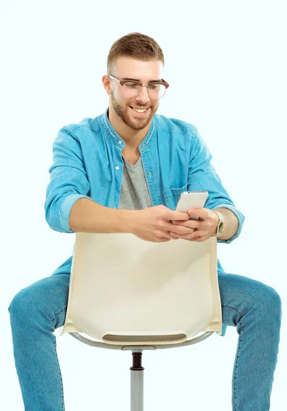 Jovem sentado na cadeira e usando telefone celular. Startupper. Jovem empresário . — Fotografia de Stock