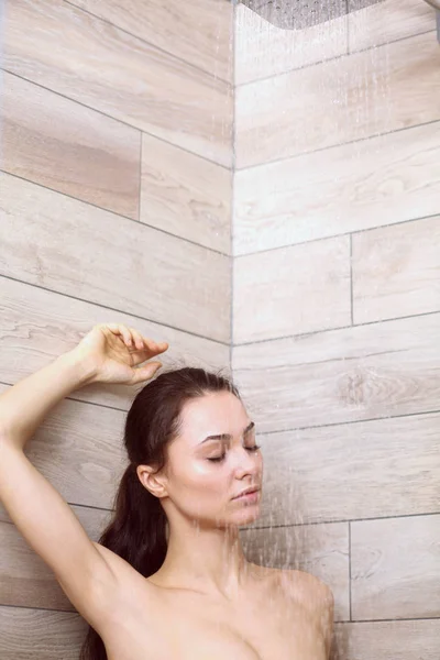 Joven mujer hermosa bajo la ducha en el baño . — Foto de Stock